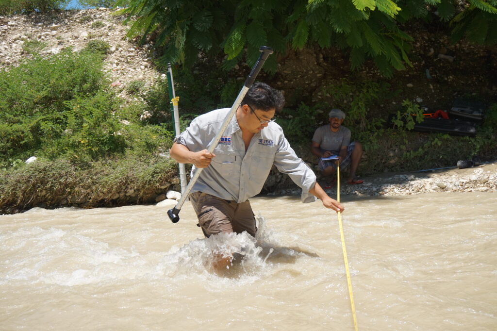 Dr. Young Gu Her measuring streamflow velocity of a river.